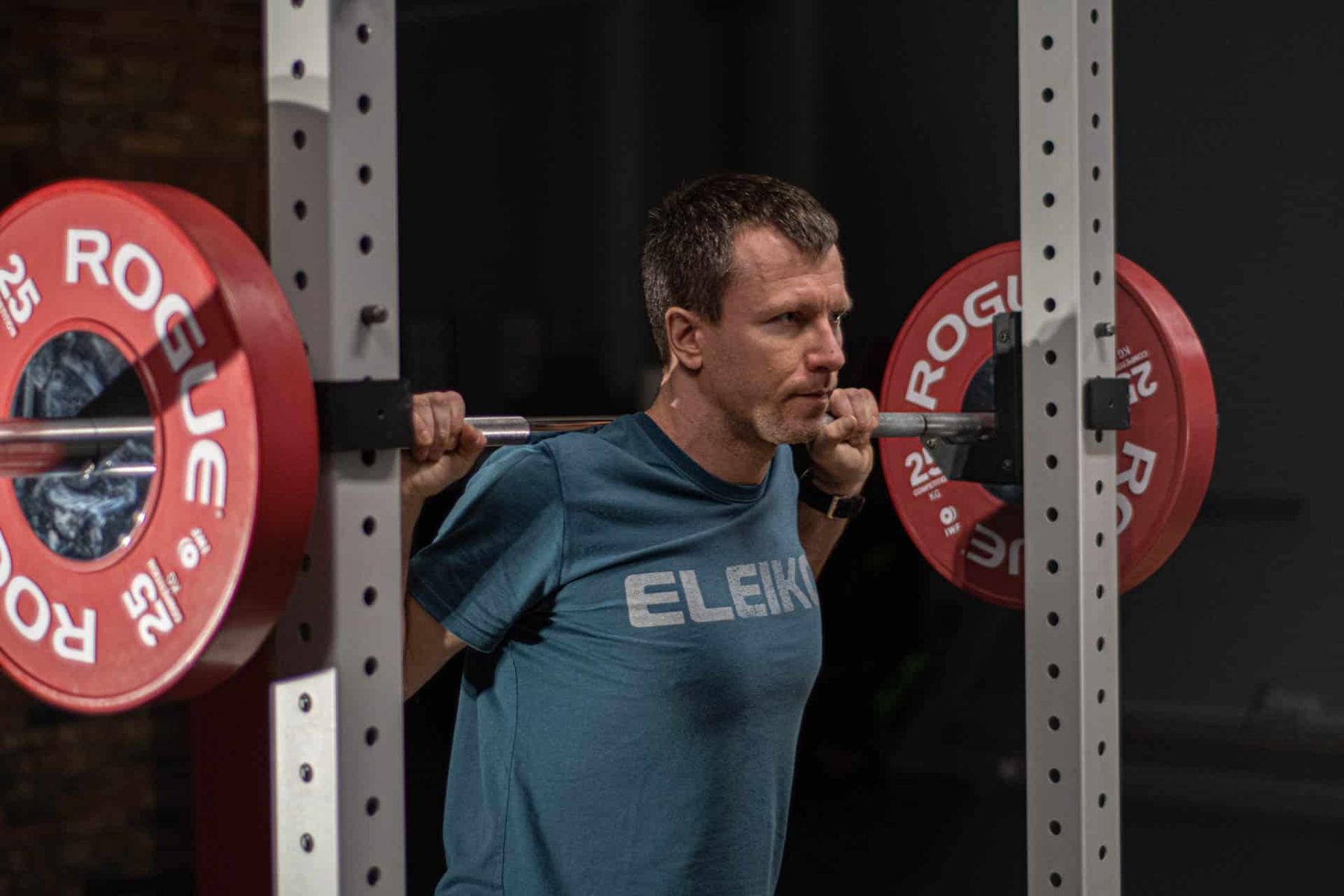 Dorian Rochowski z obciążoną sztangą na plecach w studiu Lift S&C
