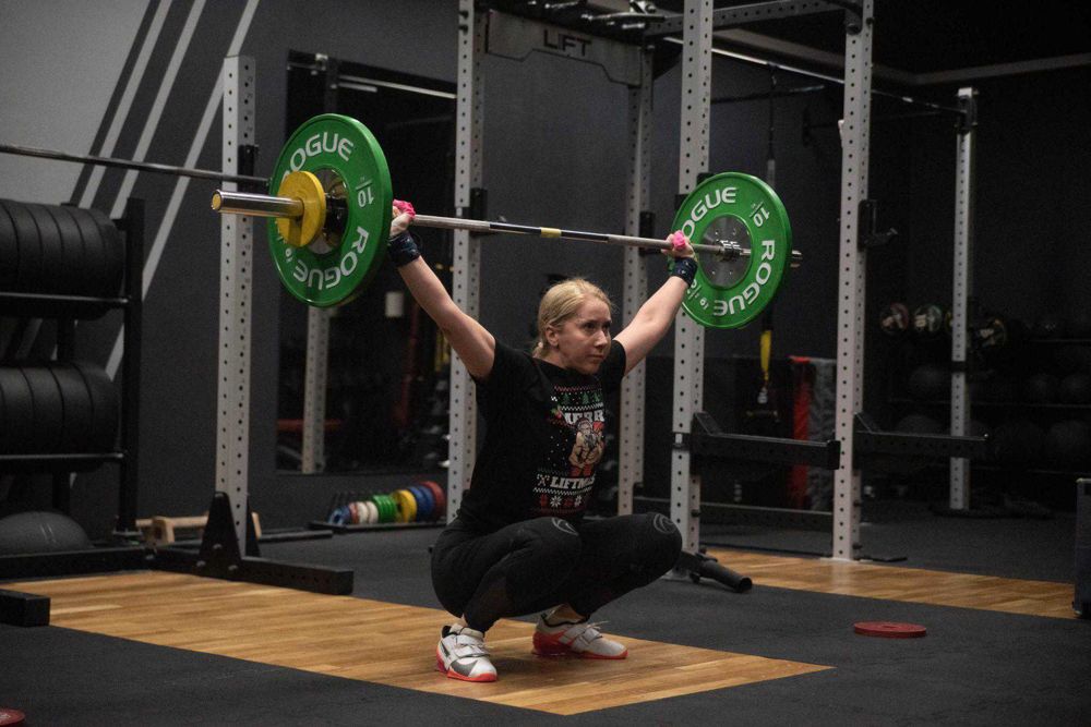 Monika w przysiadzie ze sztangą nad głową w studiu Lift S&C